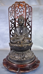 Buda sobre flor de loto. Con base de madera y biombo posterior. Alto bronce: 31 cm. Alto total: 49 cm.