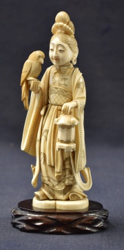 Personaje con ave y farol. figura japonesa de marfil tallado. Firmado en la base. Base de madera tallada. Alto total: 1