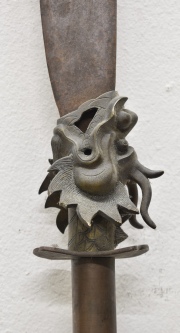 Lanza ceremonial, de hierro y bronce con figura de cabeza de dragón. Alto: 238 cm.