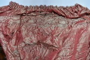 Cuatro hojas de cortinados en seda de fondo rojizo con motivos de flores. Alto: 320 cm. Ancho inferior: 196 cm.