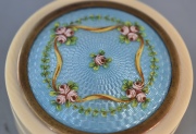 Caja de marfil y esmalte guilloche con decoración de cintas y flores. Diámetro 6 cm.