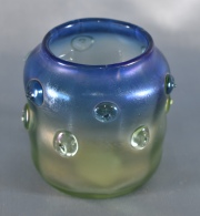 VASO DE VIDRIO IRIDISCENTE, en tonos verde y azul, con ornato de protuberancias. Alto: 8 cm.